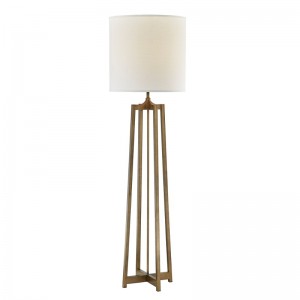 Canapea hotelului Hyatt de lângă lampa de podea cu finisaj de aur antic la camera de oaspeți