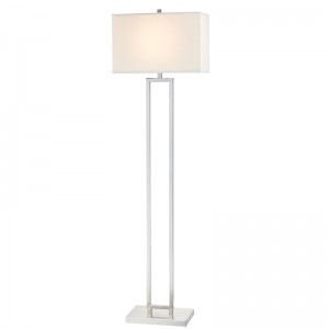 Canapeaua de hotel Marriott lângă lampa de podea cu finisaj denichel periat la camera de oaspeți